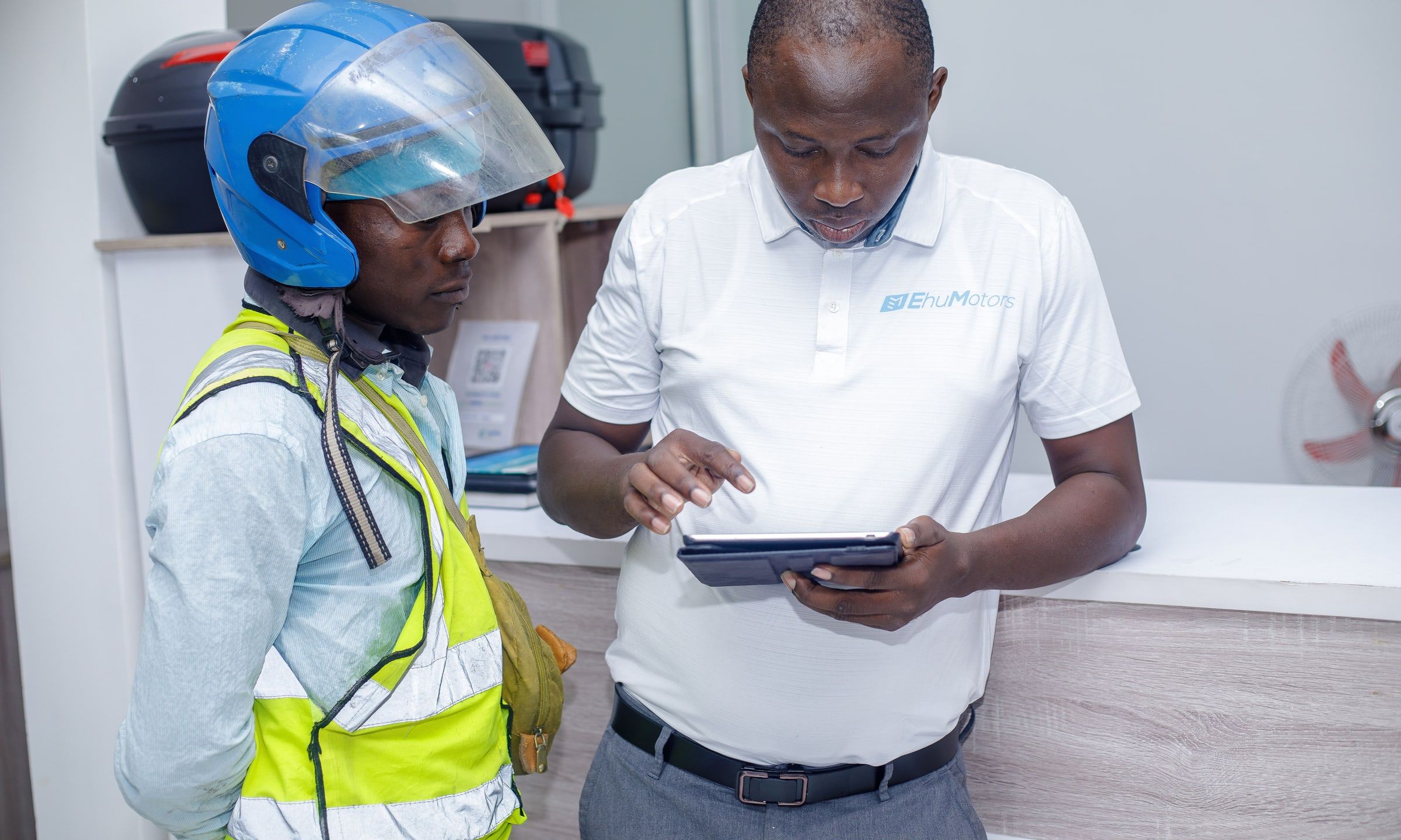 Un conseiller Ehu inscrit un conducteur sur une tablette, au showroom.