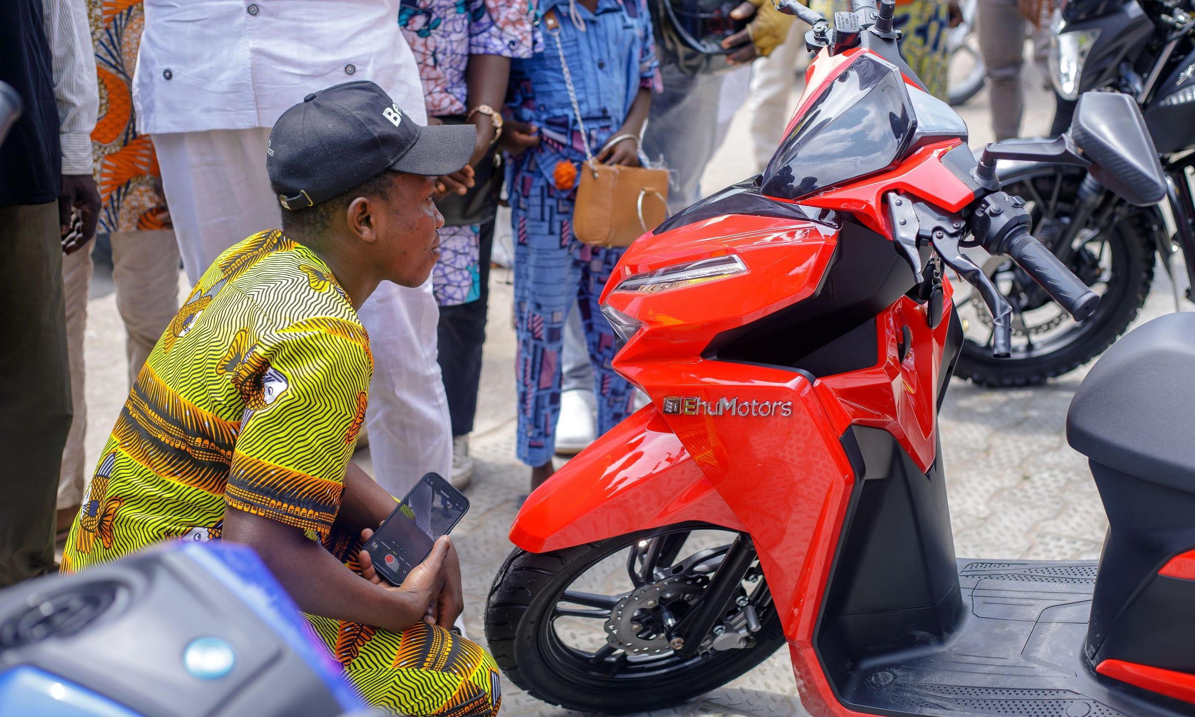 At the launch, a visitor takes a close look at a red Ehu electric scooter.